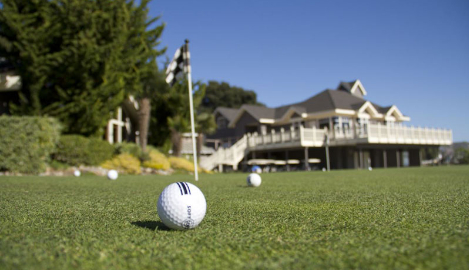 golf ball on golf course green near clubhouse